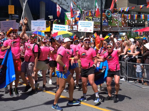 group in pride parade, men in pink t shirts