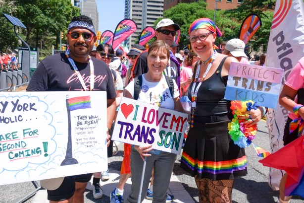 at beginning of pride parade, trans group, with signs saying protect trans kids and I love my trans son