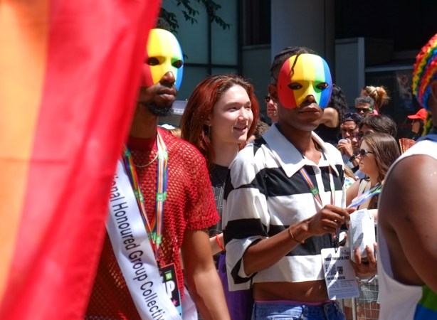 pride parade, two in rainbow masks 