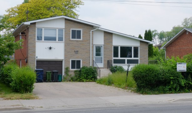 side split house from the 1960s or 1970s, now empty with a sign on the front hedge that says that it is about to be demolished