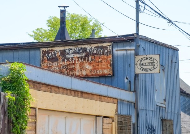 old sign on the side of a building in an alley near Dupont street, 