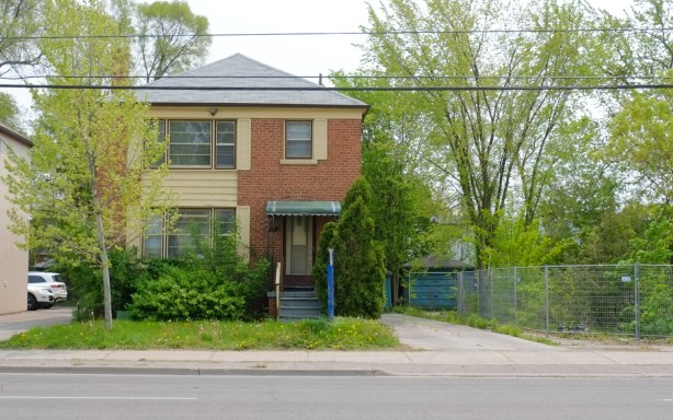 2 storey brick house on sheppard aveune, beside a vacant lot
