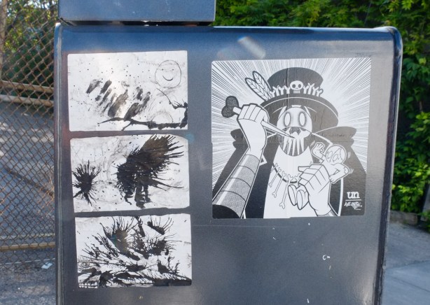 4 paste ups on a box, all black on white. One is an urban ninja squadron collaboration with ave rage, and three are inky blotty drawings