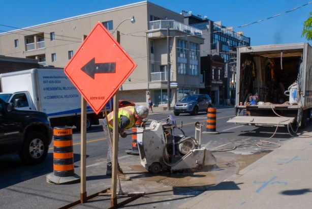 workman cutting pavement on dupont, 