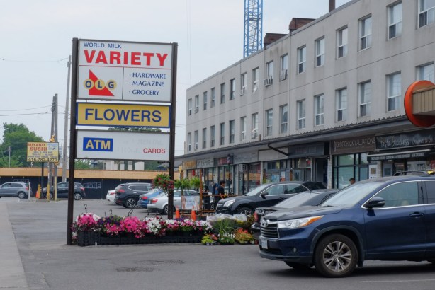 stores on the lower level of three storey concrete building, offices above, parking lot below