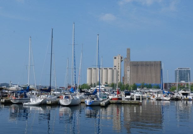 looking west along waterfront towards boats docked and silos at the foot of Bathurst street 