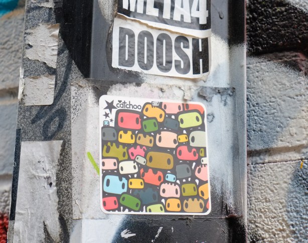 drawing by catchoo of many small different coloured faces mostly in shades of orange and green