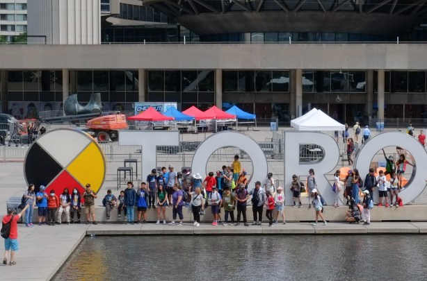 large school group getting photo taken by Toronto sign at Nathan Phillips, 3D sign, group shot, 