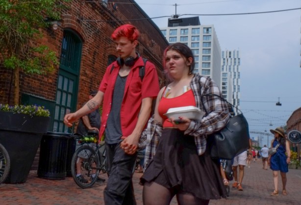 a couple walking in the distillery, he has bright red dyed hair