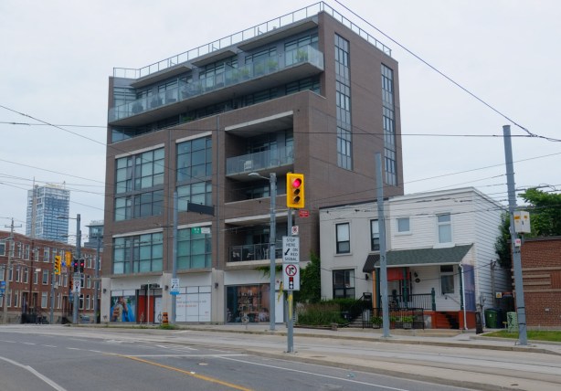 southeast corner of King and Sumach, newer 4 storey apartment building, 2 older square roofed family homes beside that