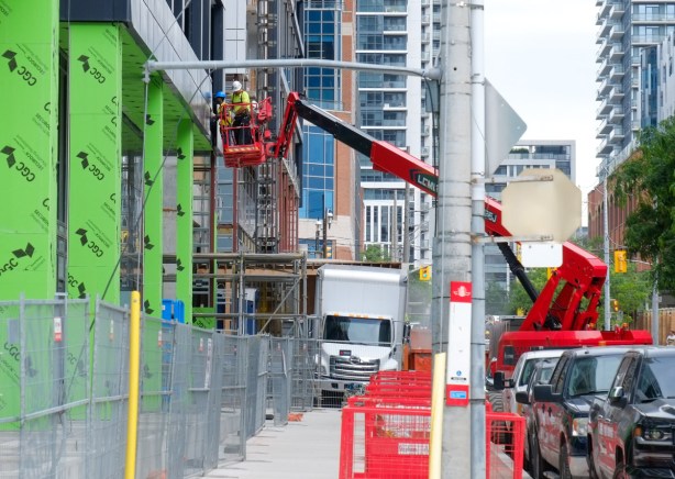 men on a red lift, construction site