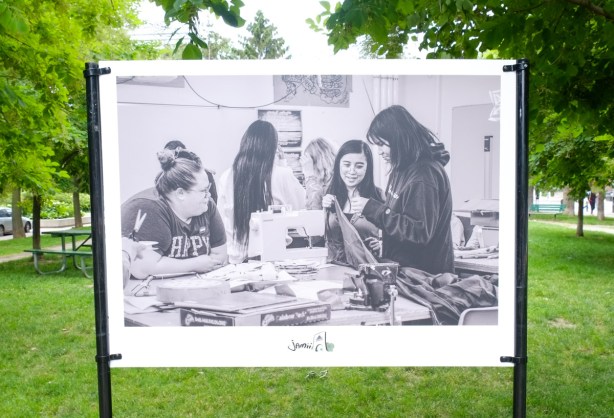 black and white painting of a group of young women sewing, sewing machine, table, in a park, part of Mashkiki project 