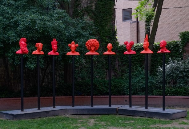 In the sculpture garden on King St., a line of red heads on poles, title of installation is Afrophilia. 