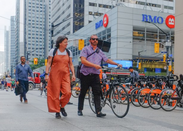 a couple walk their bike on king street