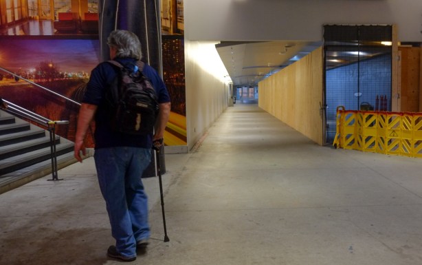 man walking with a cane, inside hallways of union station where there is still construction and renovation going on