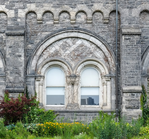 window with rounded tops, within semi circle stone work
