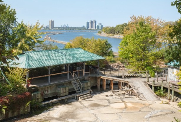abandoned waiting area and starting place for an old amusement ride, outdoors, overgrown, neglected