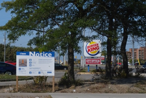 blue and white development notice sign in front of a Burger King