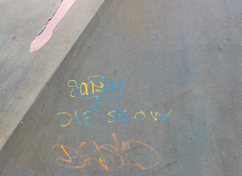 graffiti on grey wall that says die slow