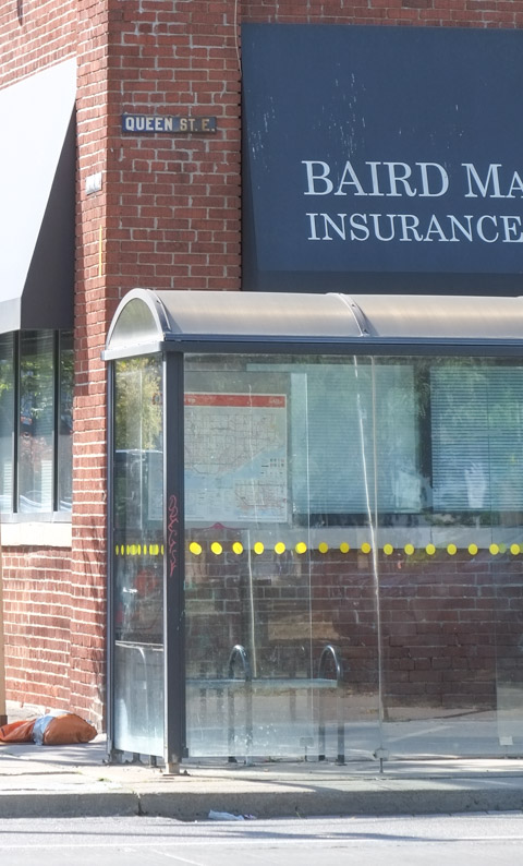 old bus shelter with curved roof and brown metal supports, 