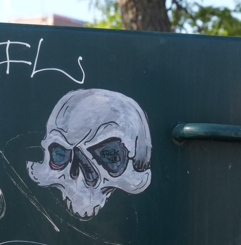 small white skull, graffiti painted on a black metal box