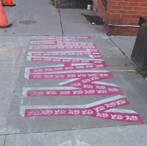 pink letters on sidewalk spell witamy which is polish for welcome, part of welcome back to main street project