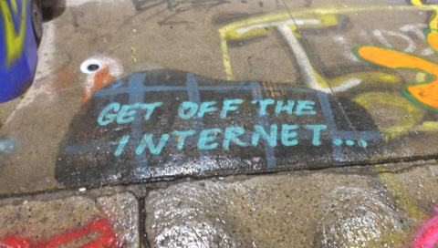 text graffiti on the pavement that says get off the internet