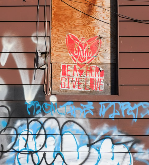 paper pasteup printed in red, on plywood board covering window