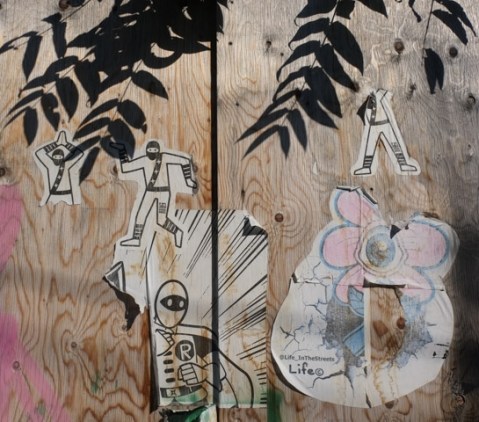 peeling pasteup graffiti on plywood