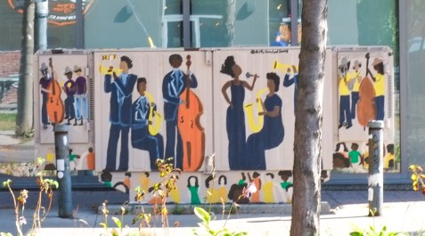 mural on a box on the street, a group of musicians playing, trumpet, bass, singing, 
