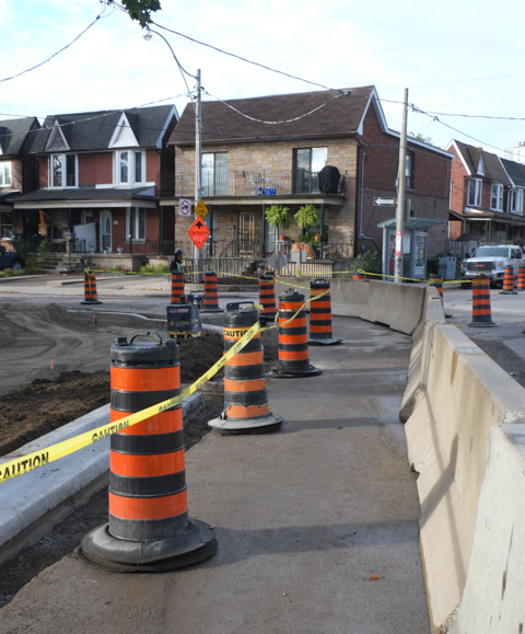 south side of intersection of dupont and emerson, houses, new sidewalk route, black and orange traffic cones