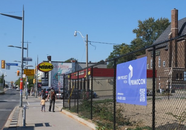 father and son walking on sidewalk, along St clair west, towards wychwood ave