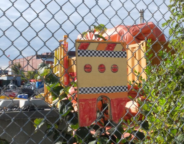 painting in yellow and red of the back of a truck, on fence