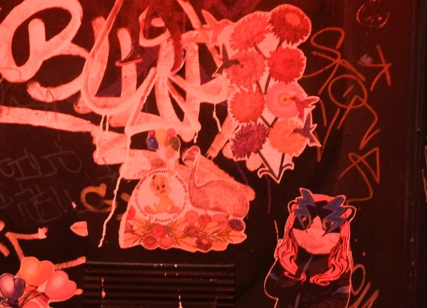 pasteups in an alley, red light, nighttime