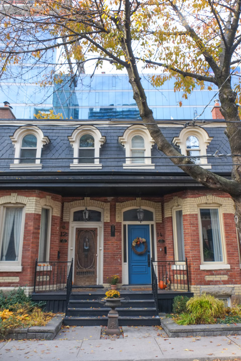 empire style row houses from the 1880s, black mansour roof, with new condos behind