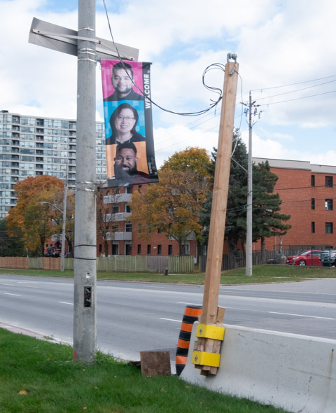 vertical banner on pole on sheppard east for east sheppard village, picture of three people on banner