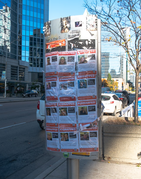 notice board on sidewalk covered with kidnapped notices of Isrealis kidnapped by Hamas in Israel