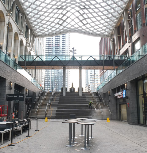stairs and escalator from lower level of the well to street level