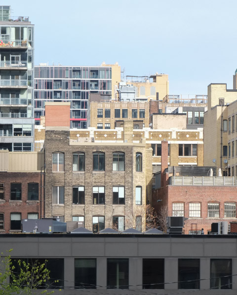 layers of midrise buildings, mostly brick, some with balconies, downtown toronto, north of wellington, west of spadina 