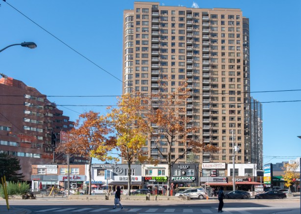 two storey shops and restaurants on west side of Yonge Street, just north of Sheppard, with large residential building behind them