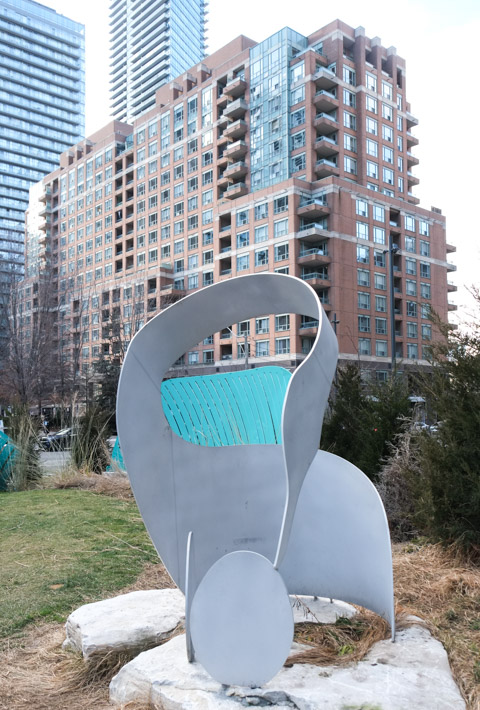 sculpture of long necked goose looking down at goose egg, in park on wellesley ave in toronto