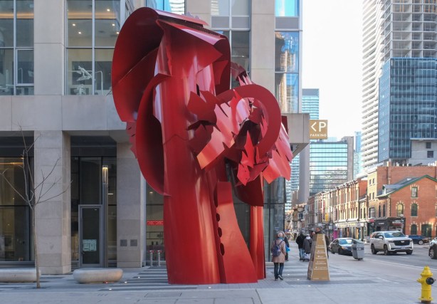 red metal sculpture on sidewalk on yonge street
