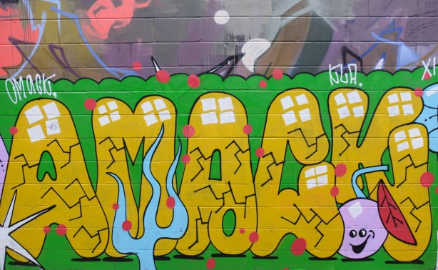 large text street art painting in yellow and green