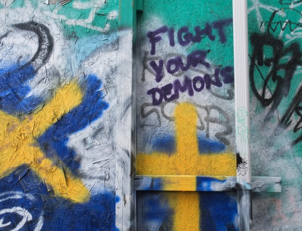 written on a wall in black paint, fight your demons