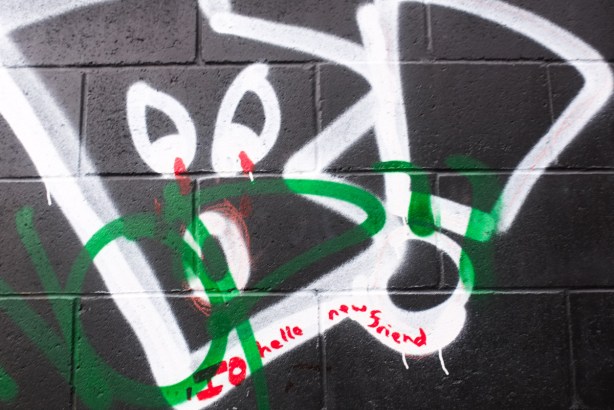 written on red on top of a black and white graffiti painting, the words, hello my new friend