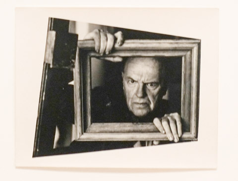 black and white photo by Arnold Newman of a man holding a picture frame around his head