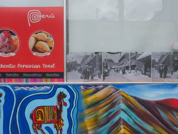 three old black and white photos of Kensington area in the window of a Peruvian store,