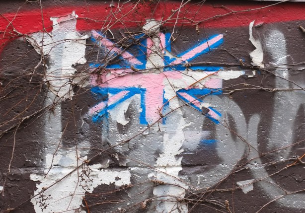 hand painted union jack on a fence but the red has faded to pink