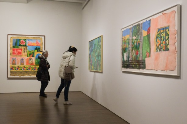 Two women looking at painting by Sarindar Dhaliwal on the wall at the Art Gallery of Ontario