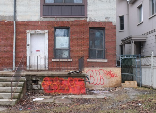old large brick house with front porch, building permit in window